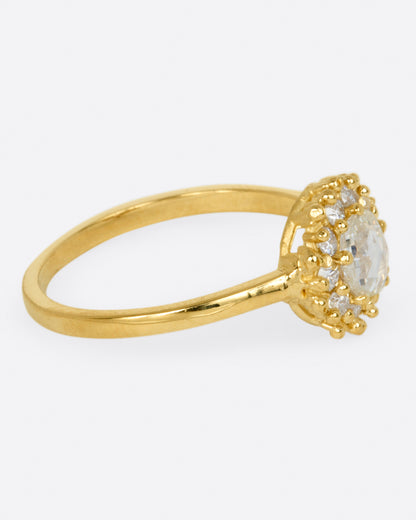 Yellow gold diamond halo ring, side view showing the profile of the setting