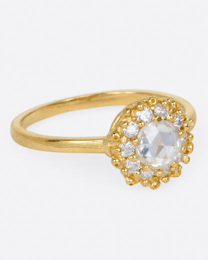 Yellow gold diamond halo ring, side view with the halo facing right