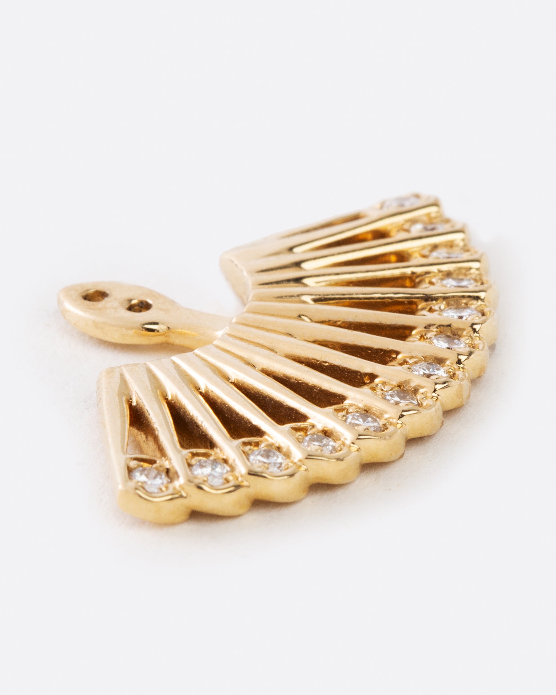A yellow gold ear jacket shaped like a fan, with two holes at the top center for adjusting where the stud earring attaches. The bottom edge is lined with white diamonds. Shown lying flat from the side.