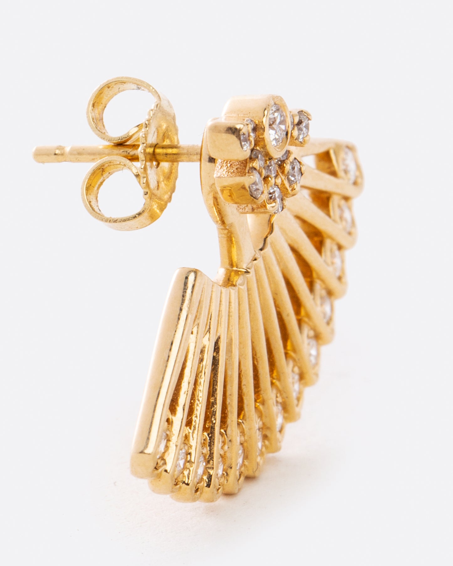 A yellow gold ear jacket shaped like a fan, with diamonds along the bottom edge. Shown from the side on a sun shaped diamond stud earring. 