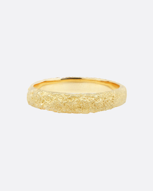 A yellow gold ring with a textural finish. Shown from the front.