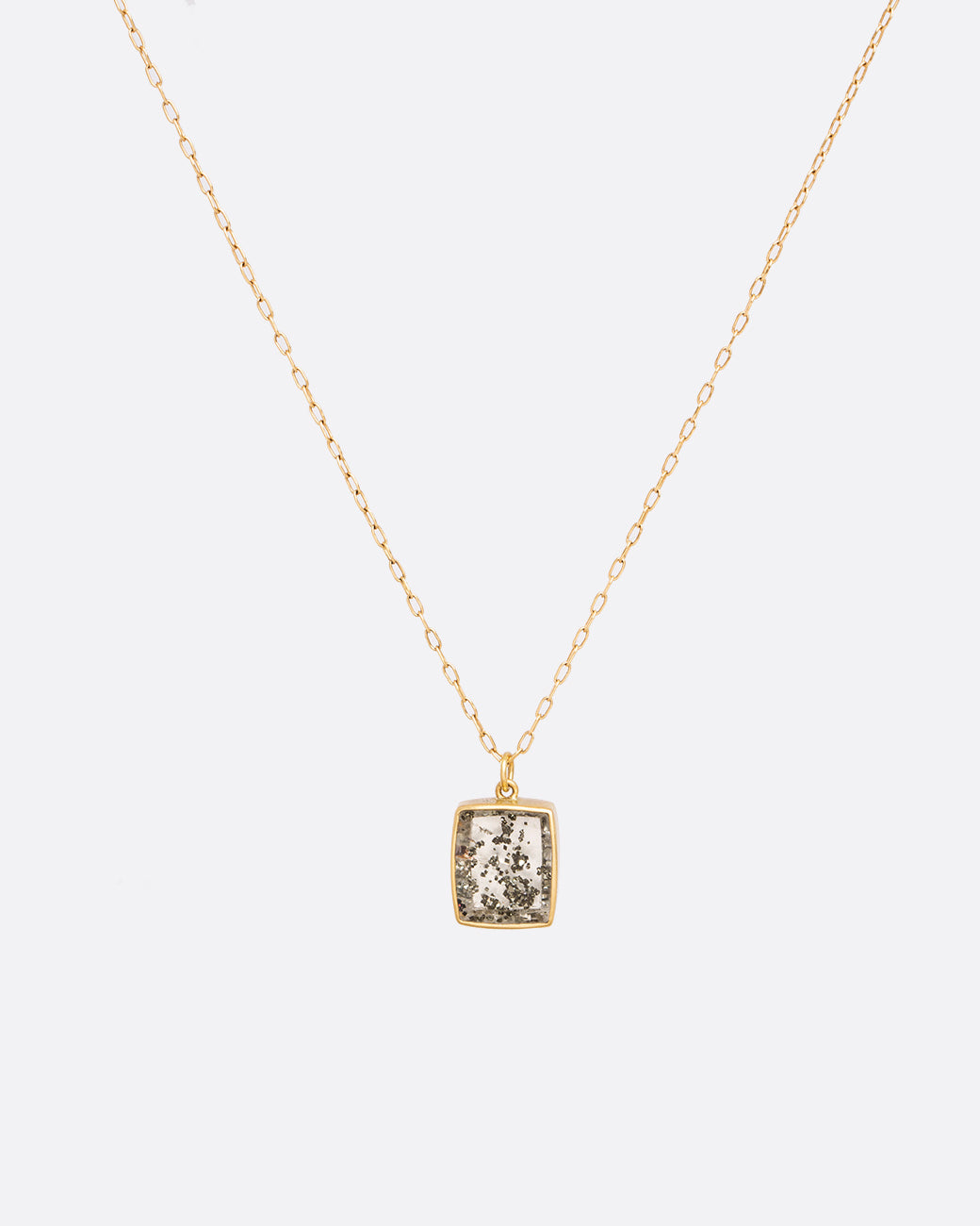 A yellow gold cable chain necklace with a quartz pendant with pyrite inclusions. Show from the front.