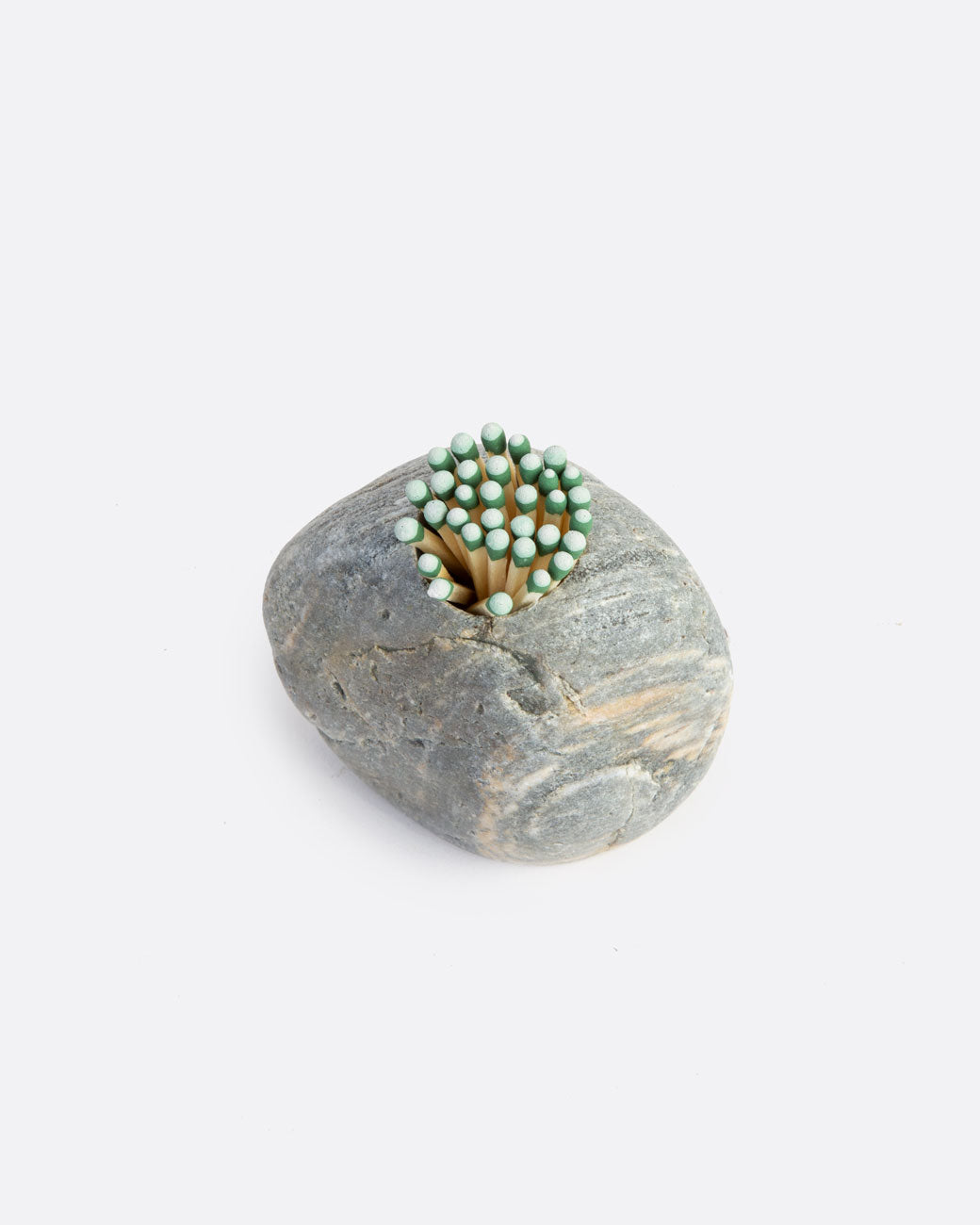 A light grey stone match striker with matches in a hole on the top. Shown from the top.