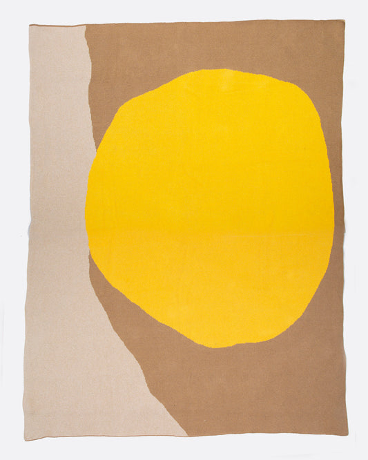 A birds eye view of blanket with a large yellow circle and two wide brown stripes. Shown open.