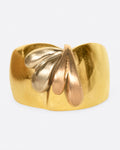 A wide, dimpled yellow gold band with white and rose gold teardrop accents. Shown from the front.