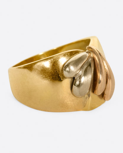 A wide, dimpled yellow gold band with white and rose gold teardrop accents. Shown from the side.
