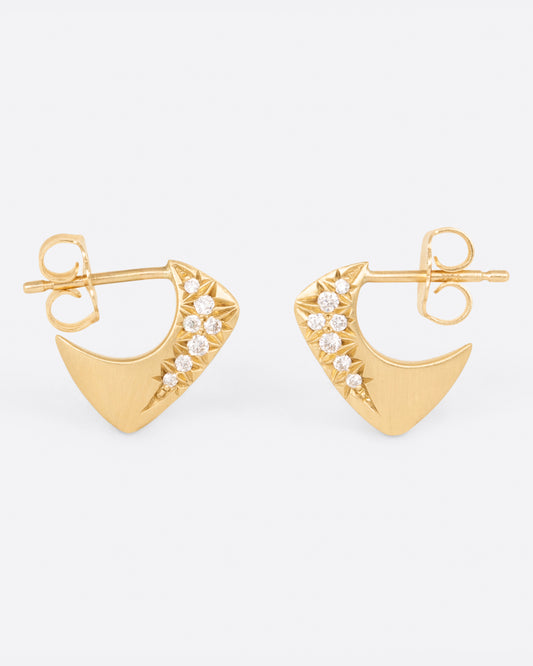 A pair of yellow gold angular huggie hoop earrings with round pave diamonds on the outside of each, shown from the side.