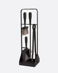 A black stand with four fireplace tools with black leather details on them. Shown from the front. 