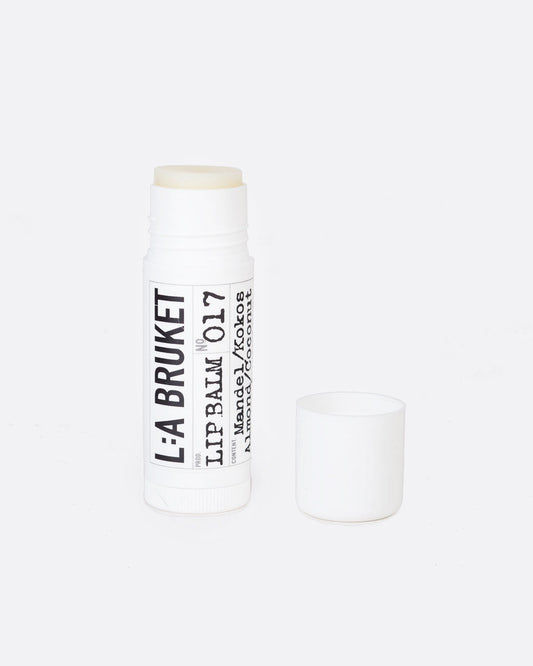 A 17 mL tube of L:A Bruket Almond & Coconut Lip Balm uncapped to show the clear white balm.
